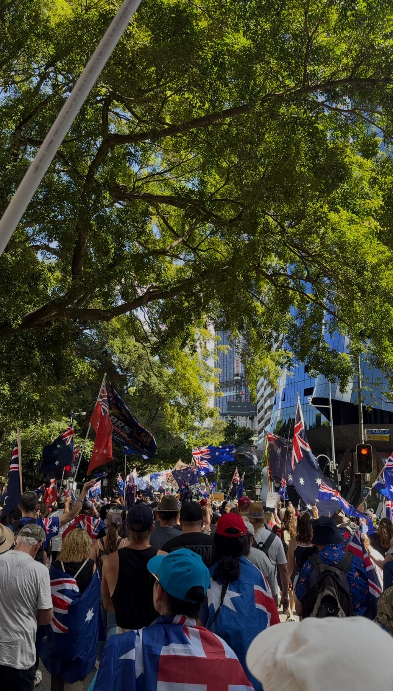 Australians marching through city streets carrying Australian flags — civic rally for accountability